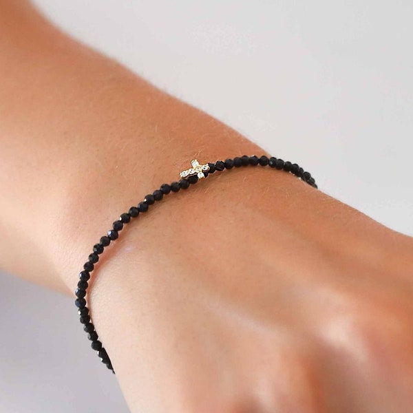 Armband aus schwarzen Spinellsteinperlen mit kleinem Zirkonkreuz und schwarzer Kordel aus vergoldetem Sterlingsilber