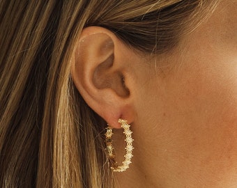 Majestic hoop earrings with suns adorning the entire hoop made of sterling silver and 24k gold plating