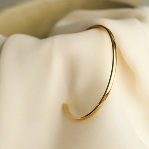 Dainty open bangle oval shape and very thin made of sterling silver and 24k gold plated silver