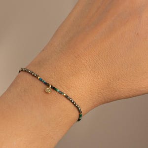Armband mit winzigen Perlen aus natürlichem Pyrit und afrikanischem Türkis mit einem herzförmigen Anhänger aus 24 Karat vergoldetem Sterlingsilber.