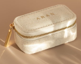 Small rectangular jewelry box with beige compartments and zipper closure. Small fabric jewelry box ideal for taking on a trip.