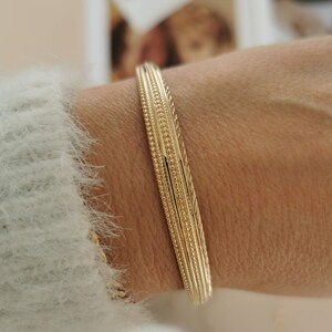 Oval cuff bracelet with fine engraved designs made of sterling silver and 24k gold plated