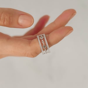 Ring with a band of golden stars surrounding from the center with green zirconia stones in sterling silver and unique design