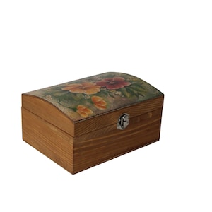 Pode incluir: Um baú de madeira com tampa curva. A tampa é decorada com um desenho floral em tons de laranja, vermelho e verde. O baú tem um fecho prateado e é feito de madeira castanha clara. Mede cerca de 20 cm de comprimento.