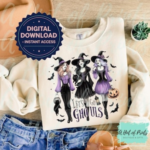 May include: Cream-colored sweatshirt featuring a graphic of three witches in black hats, holding a black cat, lantern, and pumpkin. The text "Let's Go Ghouls" is below the witches. A digital download badge is in the upper left.