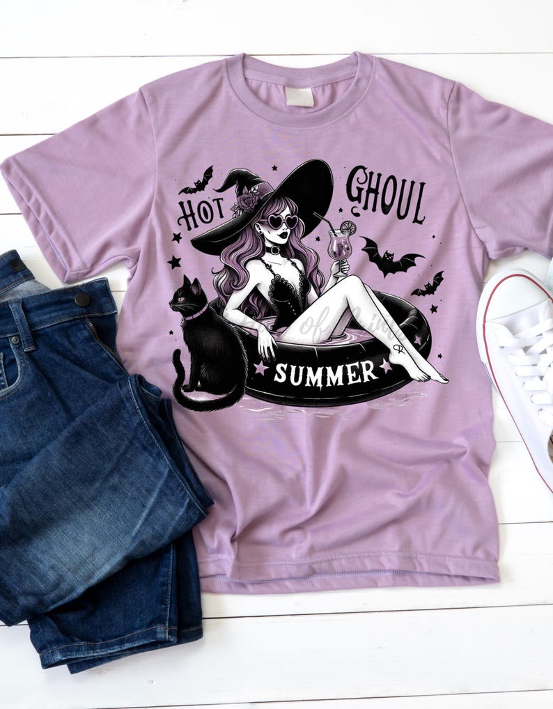 May include: A purple t-shirt with a graphic of a witch wearing a witch hat and sunglasses, floating in a pool with a black cat. The text "Hot Ghoul Summer" is printed on the shirt.