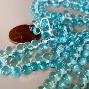 Terrific transparent aqua pressed Czech glass drops! Sold per 50 beads. SKU 09619