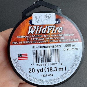 May include: Black WildFire thermally bonded bead weaving thread spool. The spool is black and orange with the text "WildFire" and "20 yd (18.3 m)". The thread is .008 in (0.20 mm).