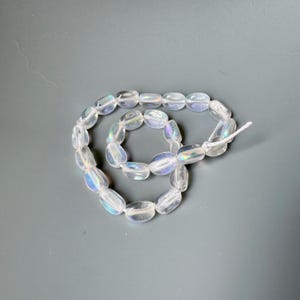 Lovely pressed Czech glass beads! Crystal AB soft triangular pinch-style beads! Sold per strand of 25 beads. SKU 06031