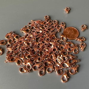 Puede incluir: Un montón grande de cierres de langosta de oro rosa. Los cierres son pequeños y delicados, perfectos para la elaboración de joyas.