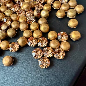 Gorgeous vintage light Colorado SS35 chatons (round rhinestones) preset in four pronged brass settings. Sold per six pieces. SKU 10628