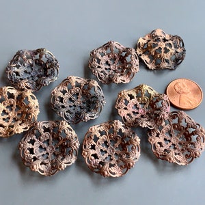 Puede incluir: Ocho adornos de filigrana metálica de aspecto antiguo en varios tonos de oro y marrón. Los adornos son circulares y presentan un diseño delicado e intrincado.