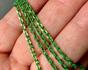 May include: Four strands of green and gold chain, with the gold running down the center of each link.