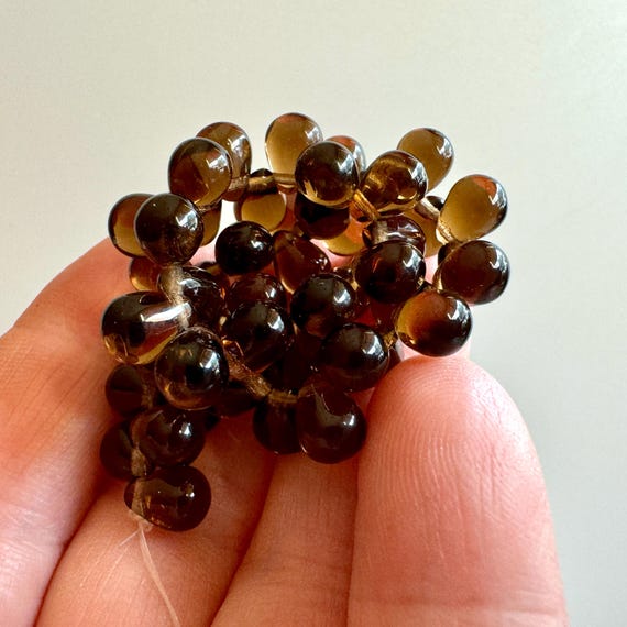 Gorgeous Czech pressed glass teardrops in transparent smokey quartz! Sold per strand of 50 beads. SKU 11506