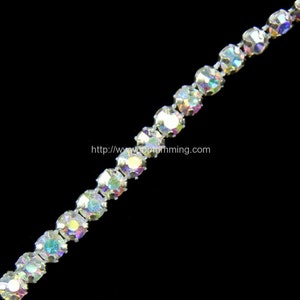 May include: A strand of iridescent clear rhinestone chain. The chain is made of small, round rhinestones that are connected by silver metal.