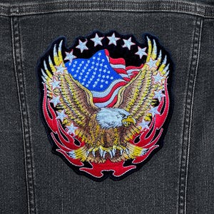 May include: A black denim jacket with an embroidered patch featuring a bald eagle with outstretched wings, a red, white, and blue American flag, and a ring of white stars.