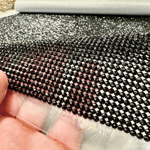 May include: Black rhinestone mesh fabric with a diamond pattern. The mesh is flexible and can be used for a variety of craft projects.