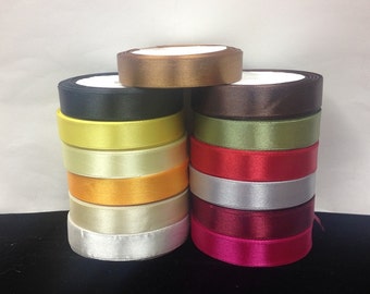 May include: A stack of 12 spools of satin ribbon in various colors, including black, brown, yellow, green, red, silver, ivory, and pink.
