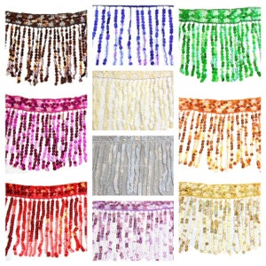 Könnte beinhalten: Sortiment aus zehn Besätzen mit Fransen und Pailletten in verschiedenen Farben, darunter Braun, Blau, Grün, Pink, Creme, Silber, Orange, Rot, Lila und Gold.