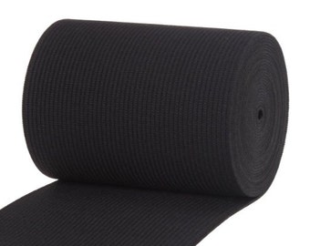 May include: A roll of black elastic trim with a ribbed texture. The elastic is rolled up and the end is unfurled, showing the texture.