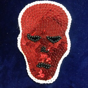 May include: Red sequin skull patch with black bead eyes.
