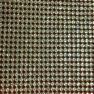 May include: A close-up of a gold mesh fabric with small, clear rhinestones. The rhinestones are arranged in a grid pattern.