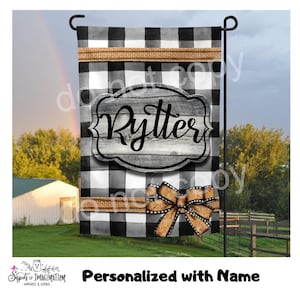 May include: A black and white checkered garden flag with the name "Rytter" on a wooden-style plaque. The flag has a burlap ribbon and bow detail. The text "Personalized with Name" is at the bottom.