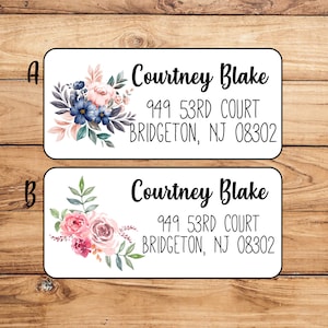 May include: Two white rectangular return address labels with floral designs. The top label has blue flowers and the bottom label has pink flowers. Both labels have the text "Courtney Blake", "949 53RD COURT", and "BRIDGETON, NJ 08302".