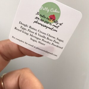 May include: A white business card with the text "Patty Cakes" in green and red. The card includes the text "To order call Patty at 209-769-2731 or email pbmomsis@gmail.com". The card also lists the ingredients used in the cakes, including butter, cream cheese, sugar, eggs, flour, vanilla bean paste, meringue powder, powdered sugar, and water.