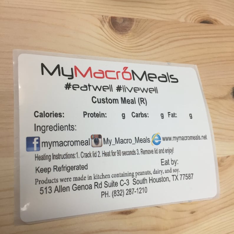May include: A white label with the text "MyMacroMeals #eatwell #livewell Custom Meal (R)" and information about calories, protein, carbohydrates, and fat.  The label also includes social media icons for Facebook, Instagram, and a website.  The label includes instructions for heating the meal, a note to keep it refrigerated, and an expiry date.  The label also includes the address and phone number for the company.