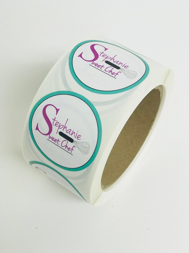 Puede incluir: Rollo de pegatinas redondas con borde turquesa y fondo blanco. Las pegatinas presentan una gran letra rosa "S" y el texto "Stephanie Sweet Chef" con un batidor negro.