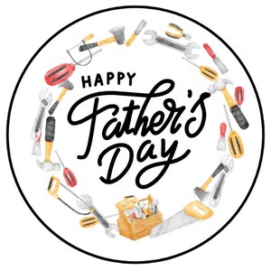 May include: A white circle with a black border, featuring a wreath of tools in watercolour style. The tools include a hammer, saw, screwdriver, wrench, and other tools. The text "Happy Father's Day" is written in black cursive lettering in the centre of the circle.