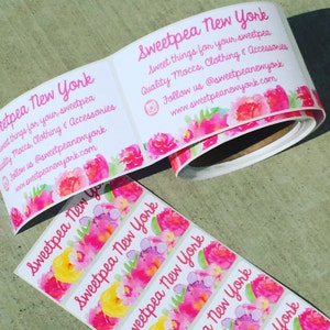 May include: Roll of pink and white floral patterned stickers with the text "Sweetpea New York" and the tagline "Sweet things for your sweetpea Quality Moccs, Clothing & Accessories Follow us @sweetpeanewyork www.sweetpeanewyork.com"