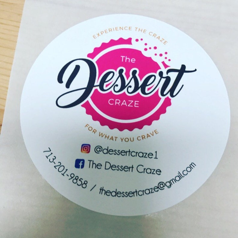 May include: A white circle sticker with pink and black text. The text reads "Experience the Craze The Dessert Craze For What You Crave" and includes the business's social media handles and phone number.
