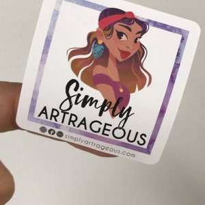 May include: A sticker featuring a cartoon illustration of a woman with brown hair, wearing a red headband, purple shirt, and gold jewellery. The text "Simply Artrageous" is written in black cursive font with the social media handle "@simplyartrageous.com" below.