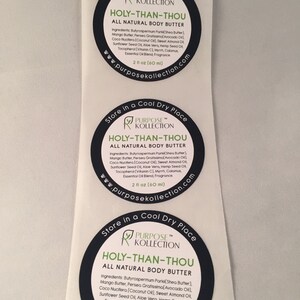 Puede incluir: Tres etiquetas redondas en blanco y negro con el texto "Store in a Cool Dry Place" y "PURPOSE&trade; KOLLECTION" en texto blanco. Las etiquetas tambi&eacute;n tienen el texto "HOLY-THAN-THOU ALL NATURAL BODY BUTTER" en texto blanco. Las etiquetas enumeran los ingredientes de la manteca corporal, que incluyen manteca de karit&eacute;, manteca de mango, aceite de aguacate, aceite de coco, aceite de almendras dulces, aceite de semillas de girasol, aloe vera, aceite de semillas de c&aacute;&ntilde;amo, tocoferol, mirra, c&aacute;lamo, mezcla de aceites esenciales y fragancia. Las etiquetas tambi&eacute;n indican que la manteca corporal es de 2 fl oz (60 ml).
