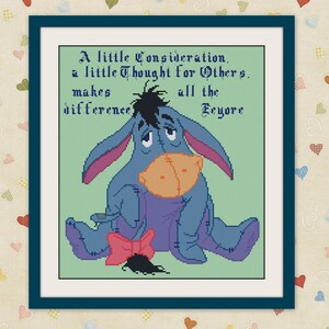 May include: Cross-stitch artwork featuring Eeyore from Winnie the Pooh, in a blue frame. The image shows Eeyore with a sad expression, holding a tan-colored object. Text reads, "A little Consideration, a little Thought for Others, makes all the difference Eeyore."