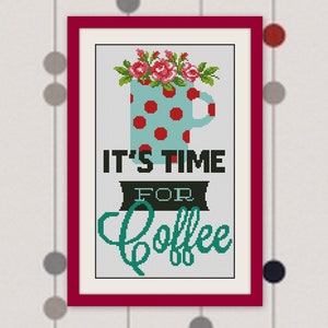 May include: Framed cross-stitch picture with a burgundy border. It depicts a teal coffee mug with red spots and pink flowers. The text "IT'S TIME FOR COFFEE" is in black and teal. The background has a dotted pattern.
