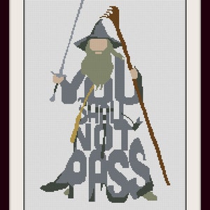 May include: Cross-stitch art featuring a character from The Lord of the Rings, holding a sword and staff. The text "YOU SHALL NOT PASS" is integrated into the design. The artwork is framed in a white border with a dark red frame.