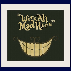 May include: Cross-stitch artwork of the Cheshire Cat's grin and the quote "We're All Mad Here" in a whimsical font. The design is on a dark green background, framed in white, and mounted on a navy blue background.
