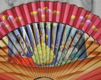 May include: A red and brown hand fan with a painted design of women in colorful dresses. The fan is closed and has a wooden frame.