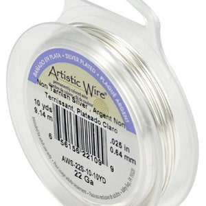 May include: A spool of silver-plated, non-tarnish wire. The spool is labeled "Artistic Wire" and includes the gauge, length, and measurements in inches and millimeters. The label also includes the text "Non Tarnish Silver, Argent Non Ternissant, Plateado Claro".