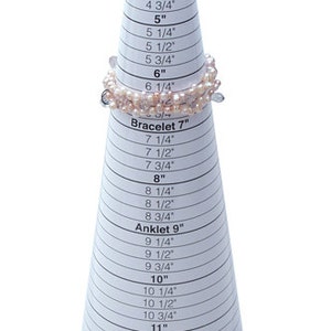 May include: A white cone-shaped tool with a printed chart for measuring bracelet and anklet sizes in inches. The chart includes measurements from 4 inches to 12 1/2 inches. The text "EZ Bracelet Patent Pending" is printed at the bottom of the cone.