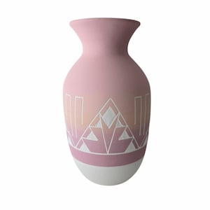 May include: A pink ceramic vase with a white geometric design. The vase has a gradient of pink and white.