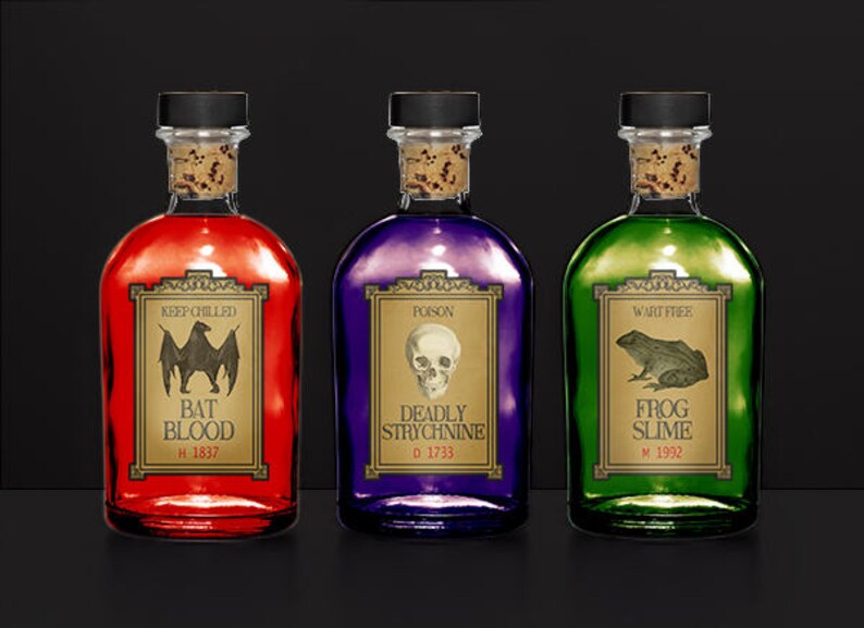 May include: Three glass bottles with cork stoppers, each filled with a different colored liquid: red, purple, and green. Each bottle has a label with a spooky theme, including a bat, skull, and frog. The labels read "Bat Blood," "Deadly Strychnine," and "Frog Slime."