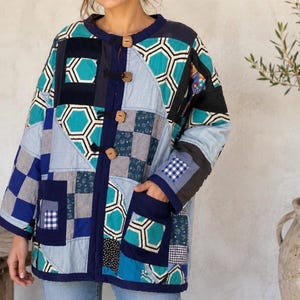 Giacca invernale patchwork realizzata a mano, unisex, nei toni del blu, turchese, vestibilità ampia e squadrata.