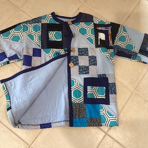 Giacca invernale patchwork realizzata a mano, unisex, nei toni del blu, turchese, vestibilità ampia e squadrata.