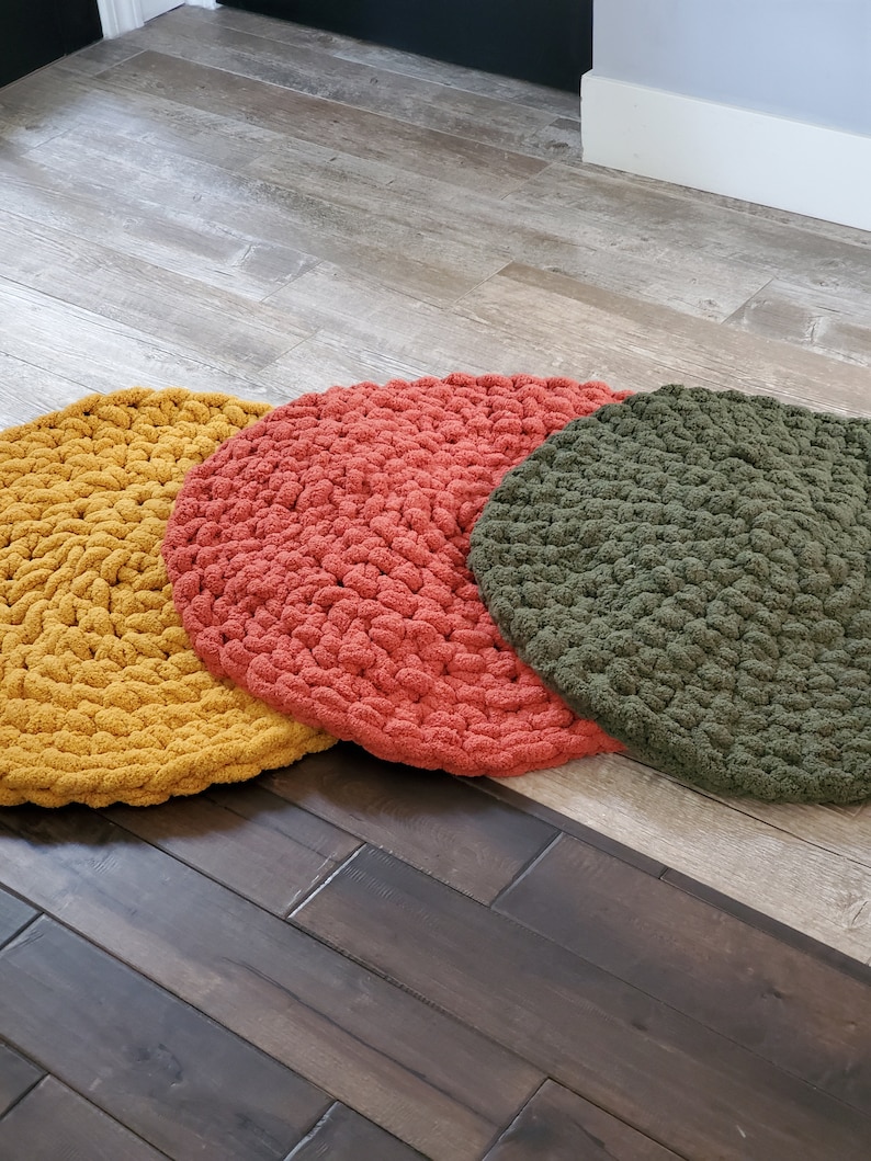 Pu&ograve; includere: Tre cuscini rotondi in crochet per il pavimento in giallo senape, arancio corallo e verde oliva.
