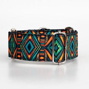 Puede incluir: Un collar de perro negro y naranja con un patrón geométrico con acentos turquesa y amarillos. El collar tiene una hebilla plateada.
