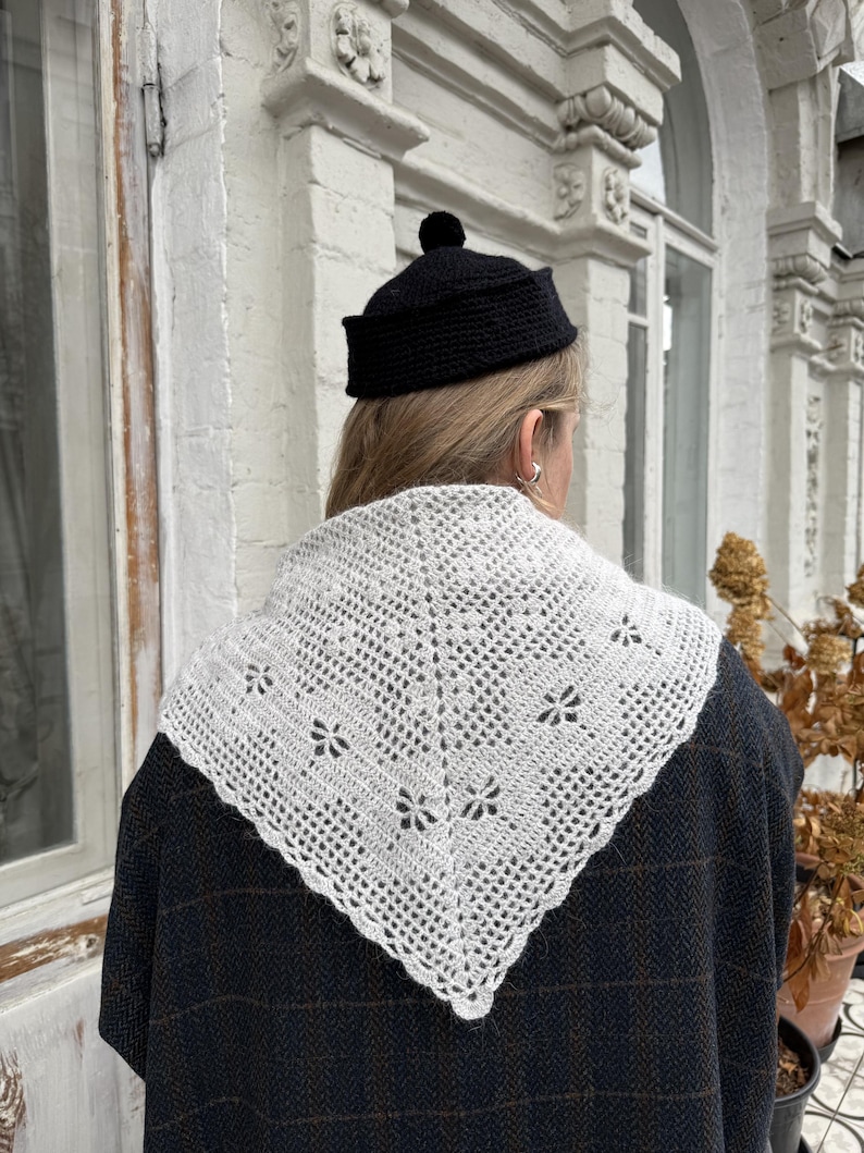 Hand knitted beige triangle scarf in soft angora blend, worn as a shoulder wrap with delicate lace pattern, cozy Scandinavian-inspired accessory for fall and winter.